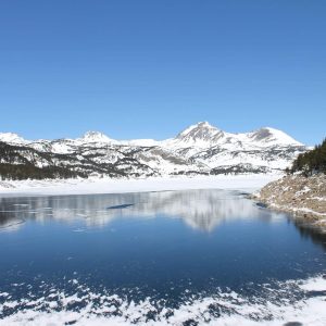 Le lac des Bouillouses gelé et les sommets enneigés vus en hélicoptère