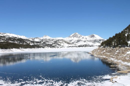 Le lac des Bouillouses gelé et les sommets enneigés vus en hélicoptère