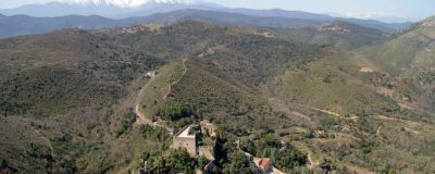 Village et château de Castelnou survolés en hélicoptère, Canigou enneigé en fond